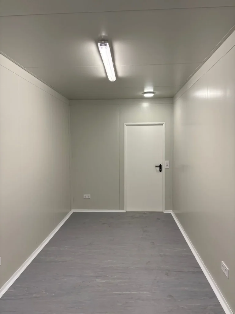 Innenraum eines Bürocontainer von Eurocontain mit weißer Farbe und einer Tür